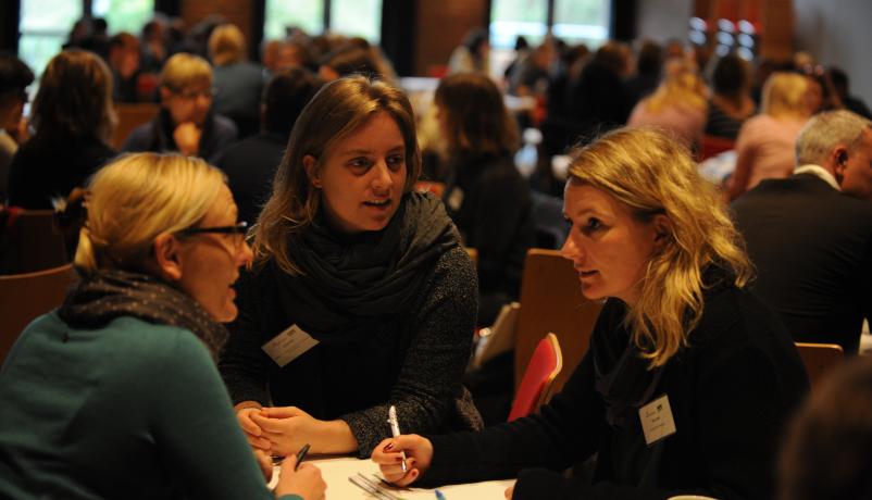 Teilnehmende diskutieren auf der Konferenz