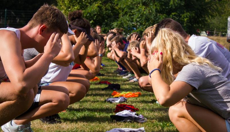 Bewegungsübungen beim deutsch-französischen Schulaustausch Jugendliche aus Deutschland und Frankreich nehmen im Freien an einer Gruppenaktivität teil, bei der sie sich gegenüberstehen und Bewegungsübungen durchführen – ein Moment aus einem deutsch-französischen Schulaustauschprojekt, das Teamgeist und interkulturelle Begegnung fördert.