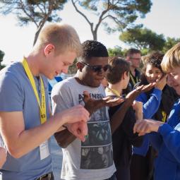 Jugendliche aus verschiedenen Ländern kommen bei einer internationalen Jugendbegegnung miteinander ins Gespräch und tauschen sich aus.