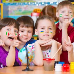 Sprachenlernen eröffnet Kindern die Welt Kinder bemalt mit verschiedenen Flaggen