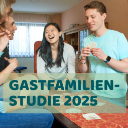 Gastfamilie und Austauschschüler:innen beim gemeinsamen Kartenspiel