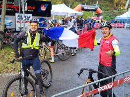 Zwei Radfahrer beim Cyclocross-Rennen in Lünen halten die französische Fahne, Austauschprojekt "Aux vélos | Auf die Räder"